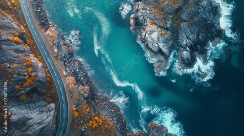Aerial view of road, rocky sea coast with waves and stones at sunset in Lofoten Islands, Norway. Landscape with beautiful road, transparent blue water, rocks. Top view from drone of highway in summer. © Wasin Arsasoi