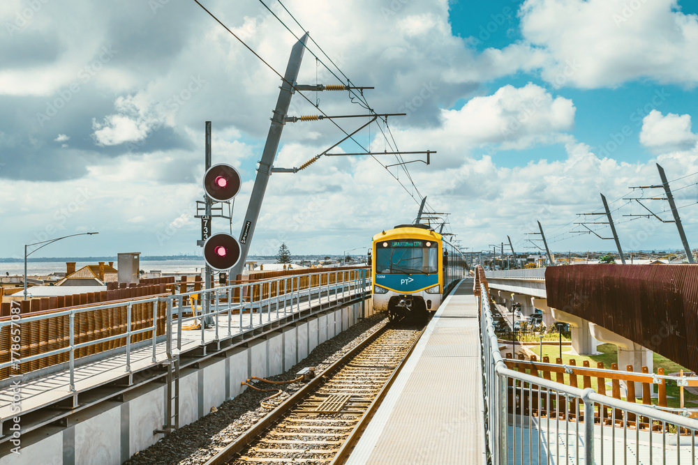Naklejka premium A train is approaching the seaside Carrum train station in Melbourne in sunny days