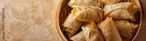 Tamales wrapped in corn husks arranged in a traditional steamer pot