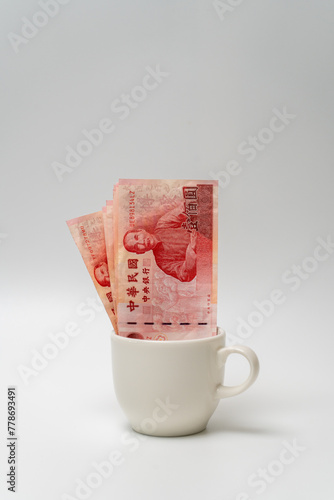 Taiwanese dollar banknote in a cup