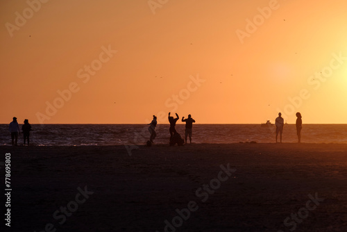 Playa de Tarifa, Cádiz, atardecer en la playa, alegria y fiesta, personas disfrutando de los últimos rayos de sol en la arena de la palya, luz dorada