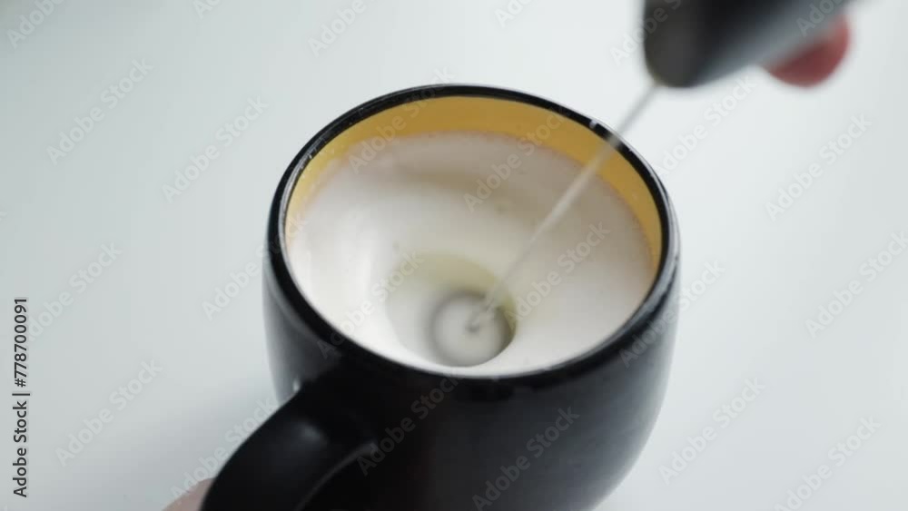 Whisking milk into froth, homemade cappuccino, morning coffee ritual Whisking milk into froth, homemade cappuccino, morning coffee ritual