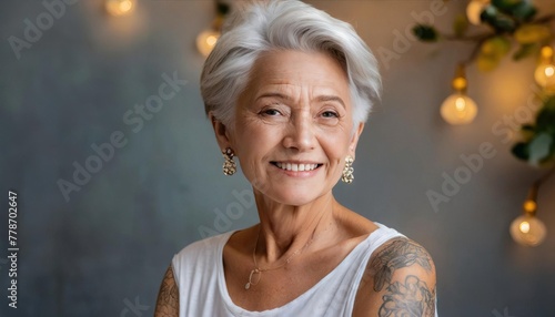 Bold elderly woman with white hair showcasing her intricate tattoos against a simple background, an embodiment of happiness, self-expression and empowering beauty photo