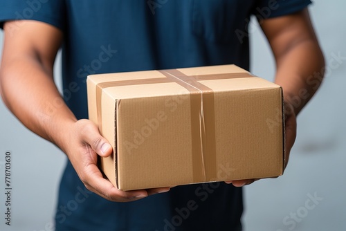 A man holds a parcel in his hands. Close-up box. Delivery of goods by mail from door to door.