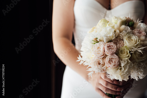 Beautiful wedding bouquet in hands of the bride. Trendy and modern wedding flowers. Soft pastels