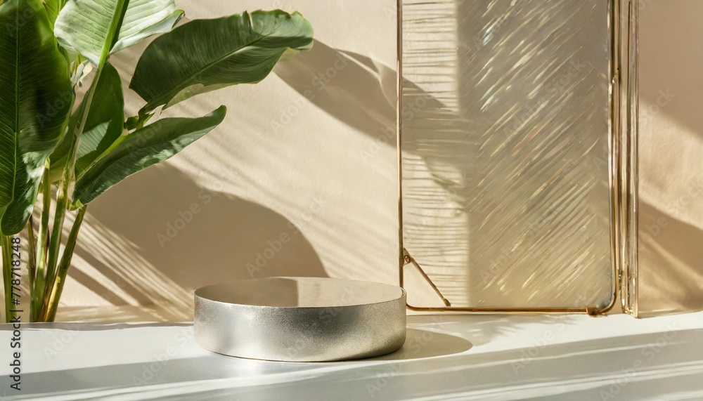 modern minimal round silver colored steel table podium with banana tree and reeded glass partition in dappled sunlight on cream colored wall for luxury organic beauty cosmetic product display