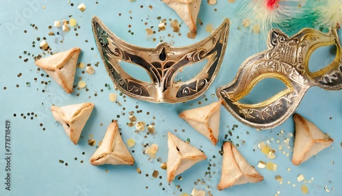 jewish holiday purim creative concept with carnival mask and hamantaschen cookies on blue background top view flat lay composition