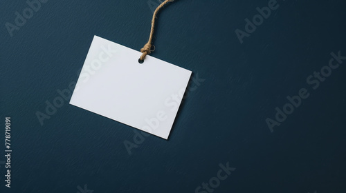 Craft paper tag with string against a contrasting blue background.