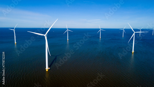 A group of wind turbines elegantly spin in the ocean off the coast of the Netherlands