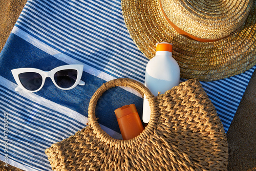 Canvas Print Beach essentials laid on striped towel at golden hour