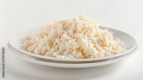 Shredded crab meat mound on white plate. Delicate texture, light sweet flavor for luxurious ravioli filling. Design for premium quality seafood concept. 