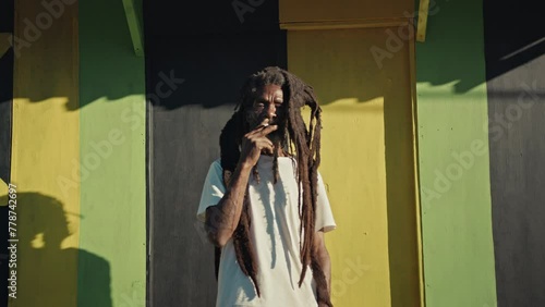 Rastafari Man in Jamaica smoking a joint while looking at the camera