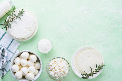 Dairy products or farm products. Fresh organic dairy products milk  cottage cheese  butter  cream  yogurt  sour cream and mozzarella on a light green slate  stone or concrete background. Top view.
