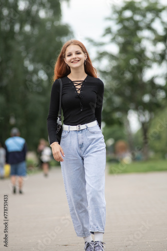 Portrait of a young beautiful red-haired girl in a summer park. © shymar27