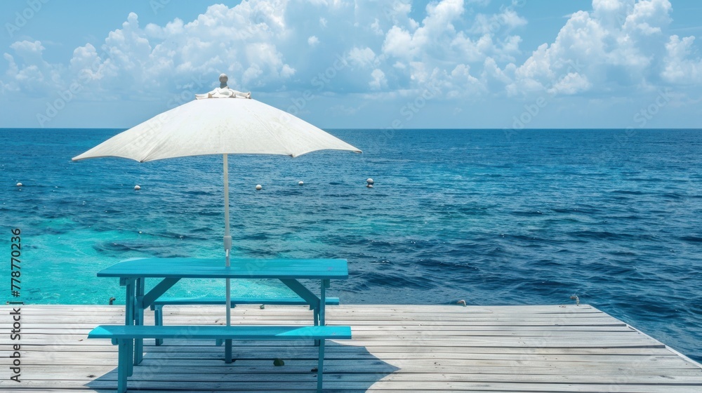 White umbrella with blue table on terrace on sandy beach near sea.AI generated image