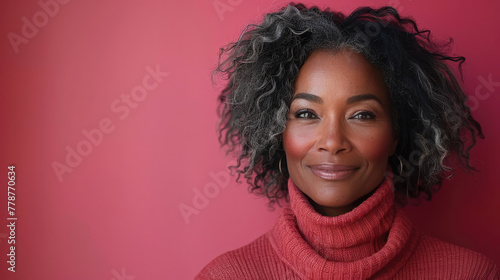 A portrait of a sophisticated mature woman with curly hair wearing a cozy red turtleneck sweater photo