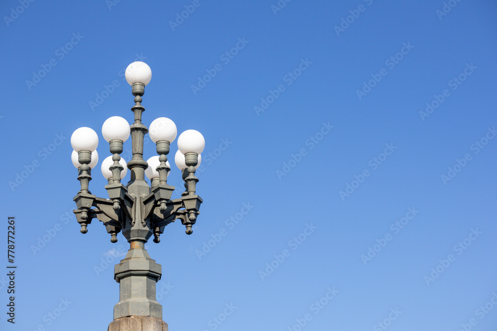 A white glass dome street lamp on a blue sky background