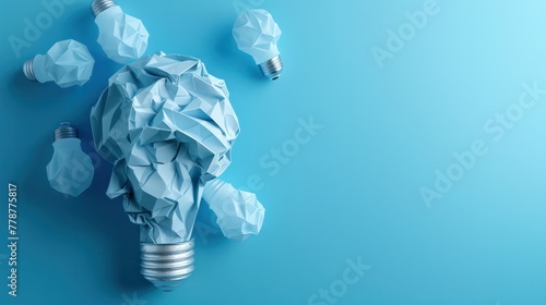 A paper light bulb is surrounded by other paper bulbs