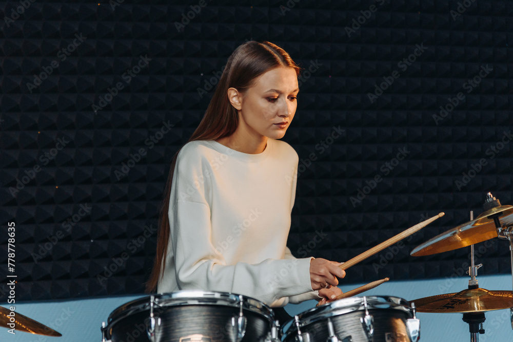 Fototapeta premium young woman playing drum set
