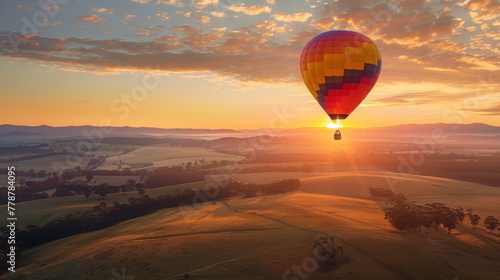 A hot air balloon ascending at sunrise over rolling hills