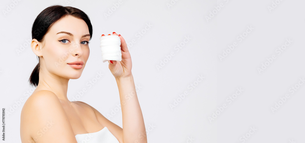 Banner with a beautiful young brunette holding sponges for cleansing her face. Advertising concept for clean skin, facial care and natural cosmetics. Banner with a beautiful young brunette holding sponges for cleansing her face. Advertising concept for clean skin, facial care and natural cosmetics.