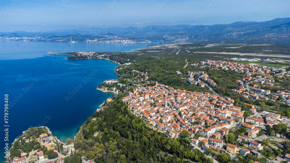 Omišalj, a charming old town perched on a cliff overlooking the Adriatic Sea, is situated on the picturesque Krk Island in Croatia captured from a drone