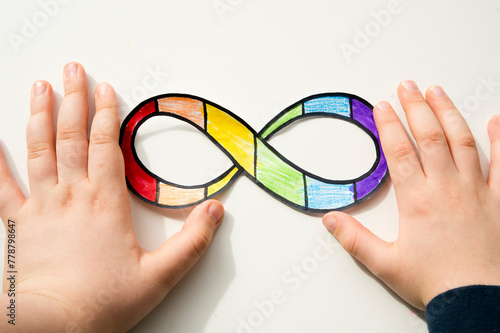 Autism infinity rainbow symbol sign in kid hand. World autism awareness day, autism rights movement, neurodiversity, autistic acceptance movement
