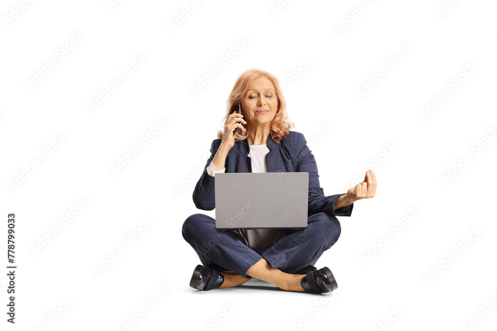Woman sitting and practicing meditation while working on a laptop computer and making a phone call Woman sitting and practicing meditation while working on a laptop computer and making a phone call