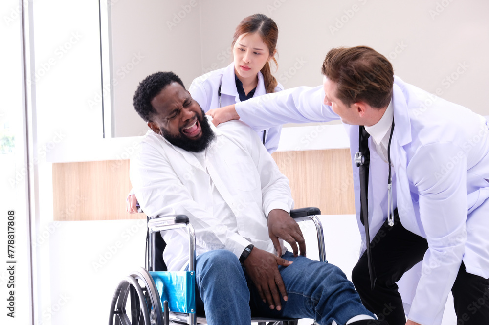 Doctors care for a male patient with a foot injury sitting in a wheelchair in the hospital. Doctors care for a male patient with a foot injury sitting in a wheelchair in the hospital.