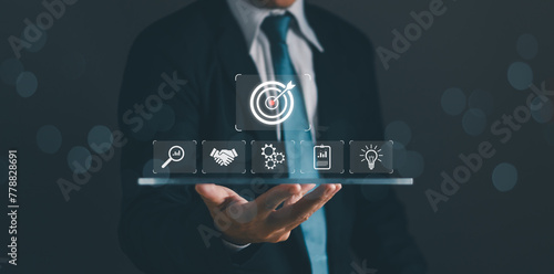Obraz na plátne target and goal Business concept,Businessman shows dartboard and arrows for targ