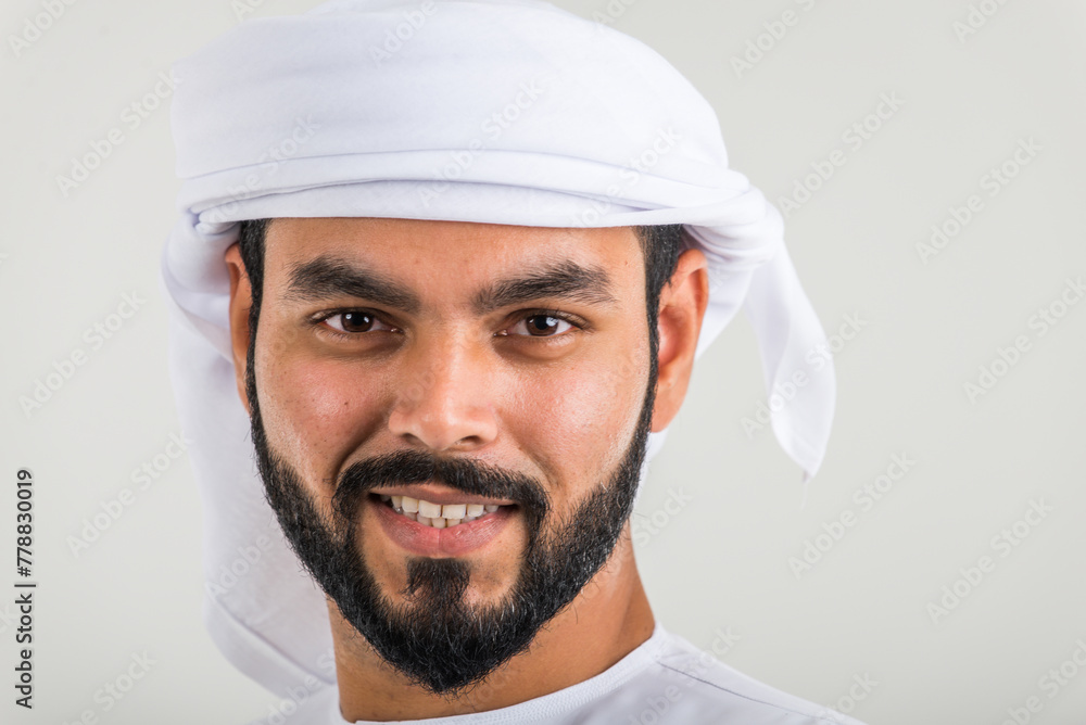 Handsome middle-eastern man wearing emirate traditional clothing portrait in studio Handsome middle-eastern man wearing emirate traditional clothing portrait in studio