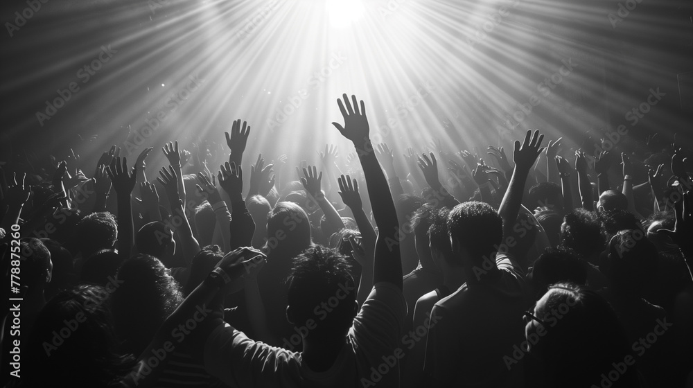 people at concert in a crowd of lights and raised hands