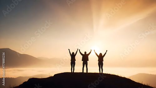 Success concept, Silhouette of a Three people with arms raised up in the mountains at sunset