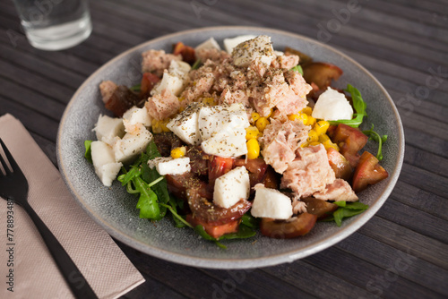 Fish salad with canned tuna and corn, tomatoes and arugula
