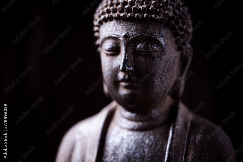 Meditating Buddha Statue on dark background. Soft focus. Close up. Copy space.	