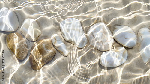 Smooth, colorful stones contrast with clear ocean water lapping at the white sand beach photo
