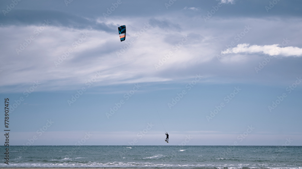 Hombre navega en una cometa en el mar en un día soleado en la costa mediterránea. Hombre navega en una cometa en el mar en un día soleado en la costa mediterránea.