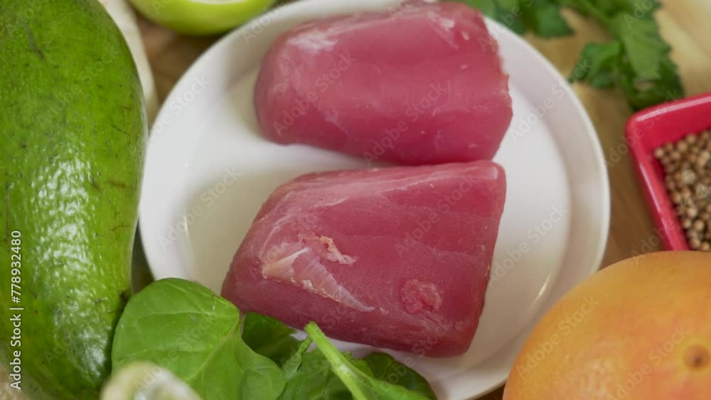 Tuna fillet with fresh vegetables and greens as ingredients for cooking tuna steak Tuna fillet with fresh vegetables and greens as ingredients for cooking tuna steak