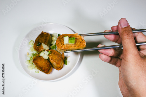Asian food called gohyong, served without sauce, held with iron chopsticks