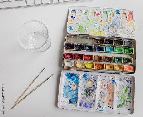 Alter Farbkasten auf einem Schreibtisch © by-studio