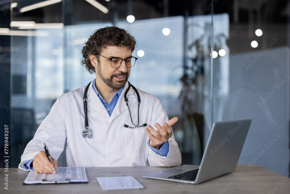 Professional male doctor with stethoscope engages in a video call consultation with a patient using his laptop in a modern clinic office. Professional male doctor with stethoscope engages in a video call consultation with a patient using his laptop in a modern clinic office.