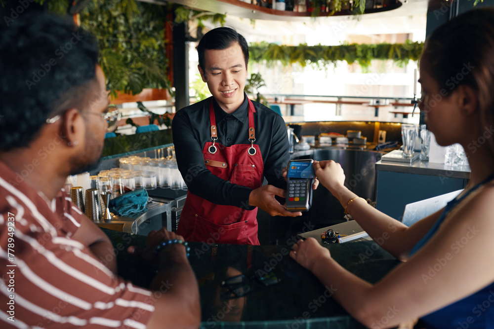 Woman paying bill for herself and her date in bar Woman paying bill for herself and her date in bar