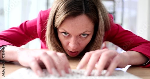 A business woman lying on the table typing on a computer keyboard, a close-up. Office workload, deadline