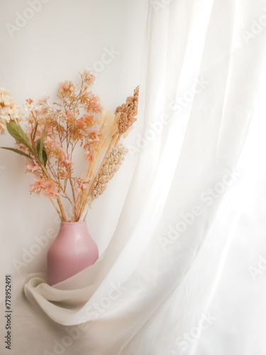 Flower arrangement in a light pink vase with white draped fabric and copy space. Whimsical, light, airy, glowy, fairytale like edit