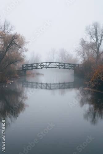 Lonely bridge over a calm river, fog obscuring the other side photo