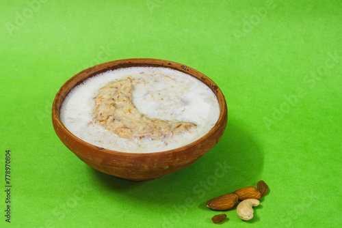 Eid mubarak with lachchha sewai or saemiya payasam or shevai served on earthen bowl for iftar during ramadan month. This sweet dish is made with vermicelli, milk, dry fruits during eid festival. photo