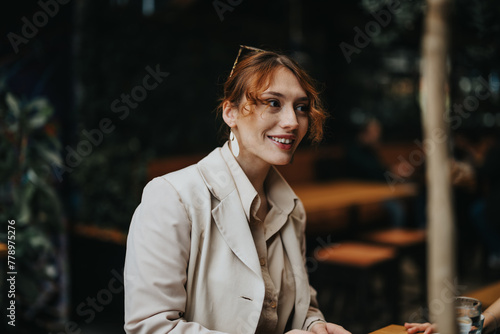 Portrait of a smiling businesswoman at an informal business gathering, discussing work with a positive attitude. © qunica.com