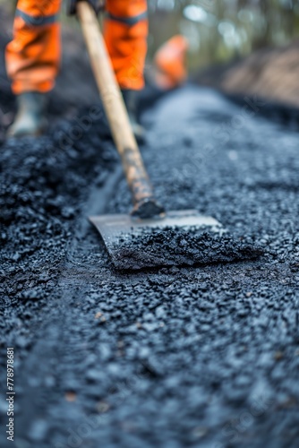 Worker laying new asphalt road pavement in residential area 