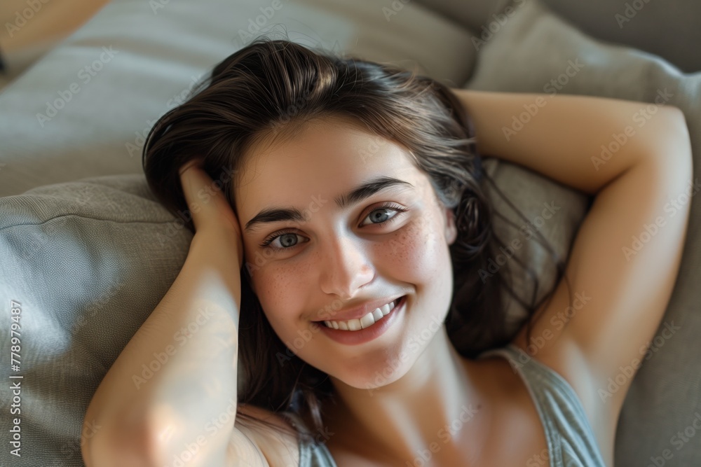 Young beautiful woman smiling at camera while relaxing at home Young beautiful woman smiling at camera while relaxing at home