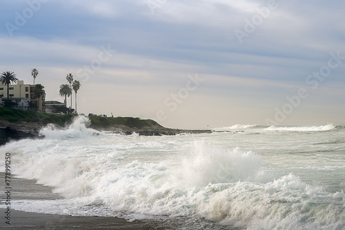 2023-12-31 ROUGH WAVES CRASHING ON THE SHORE IN LA JOLLA DURING A STORM WITH THE SHORELINE AND A NICE SKY NEAR SAN DIEGO CALIFORNIA